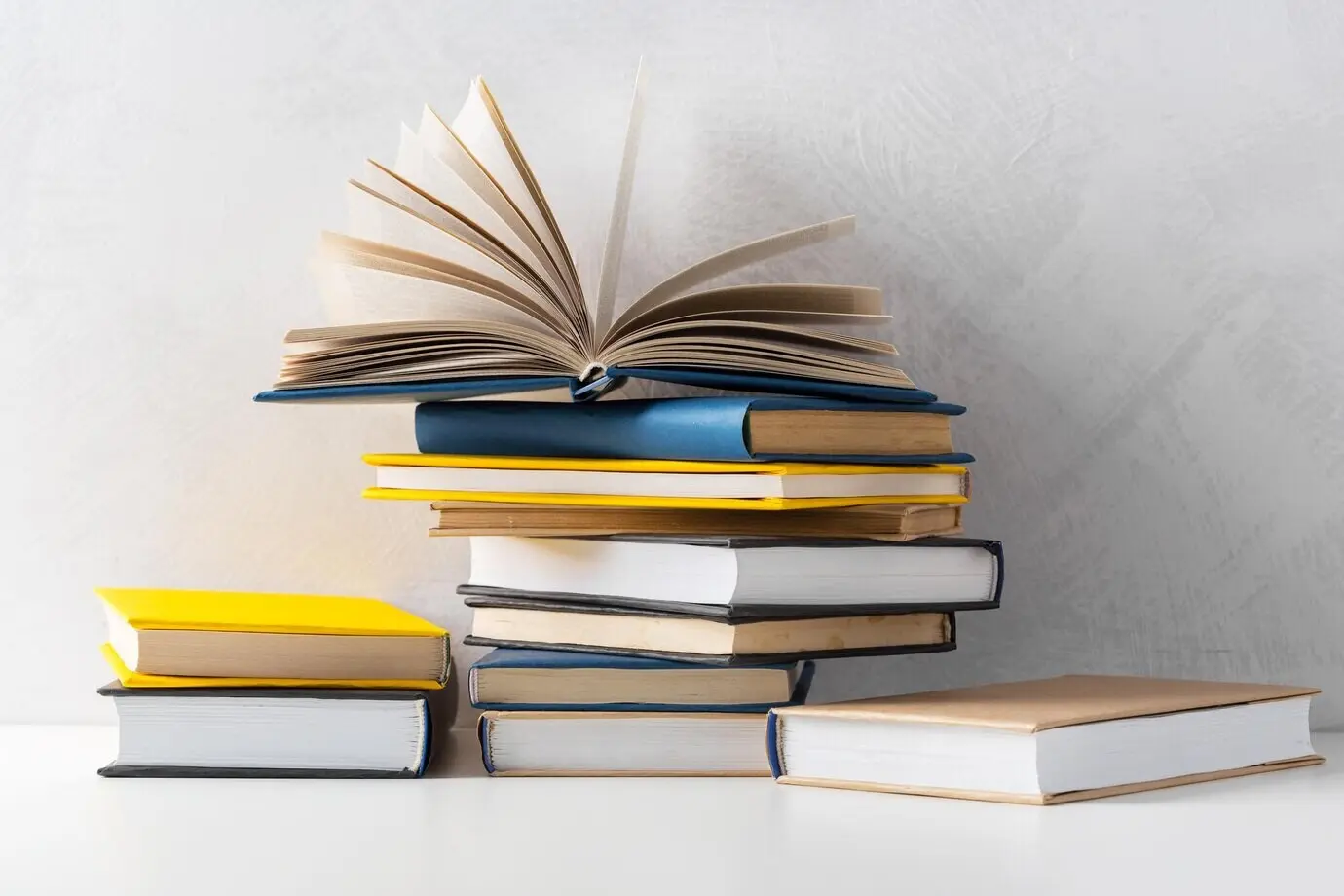 Auf einem Tisch liegt ein Stapel Taschenbücher.